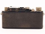 a black camera with a silver lens on a white background