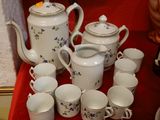 many cups and teapots sitting on a red table