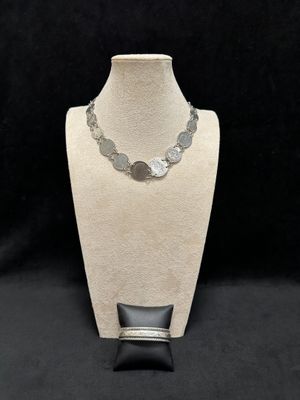 a necklace and bracelet set on a mannequin stand