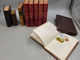 Plusieurs vieux livres sont posés sur une table près d'une fenêtre