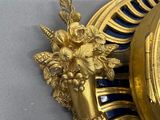 a gold clock with a blue and white design on it