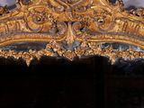a mirror with a gold frame on the wall