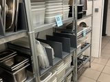 many shelves with pots and pans on them in the kitchen