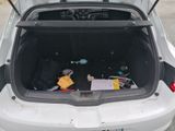 trunk of a white car with luggage in the back of it
