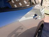 a reflection of a building on the side of a car