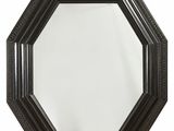 un miroir octogonal noir avec un cadre en métal et un crochet en métal