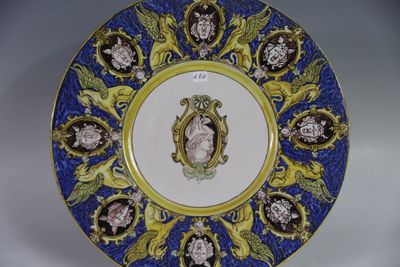 une assiette bleue et jaune sur laquelle est représentée une femme