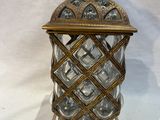 an image of a glass and brass candle holder with a bird on top