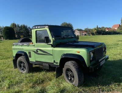 une photo d'un Land Rover vert garé dans un champ