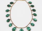 un gros plan d'un collier vert sur fond blanc