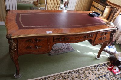 un bureau avec un plateau en cuir et une chaise dans une pièce