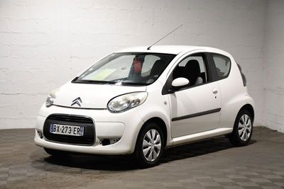 une petite voiture blanche garée dans un garage