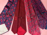 several ties are arranged in a row on a pink background