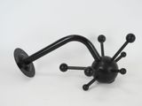 a black object that looks like a spider on a white background