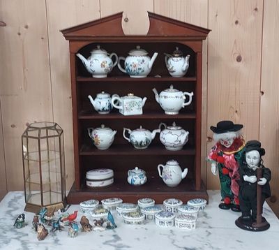 une étagère sur laquelle sont disposées de nombreuses théières de styles variés