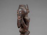 a wooden statue of a man with a hat on his head