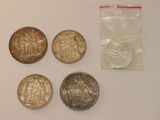four coins are sitting on a table next to a plastic bag