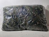 un sac en tissu camouflage posé sur une surface blanche