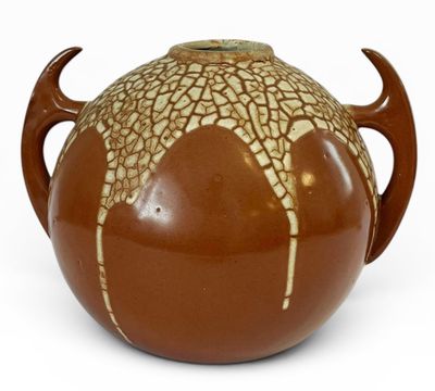 un vase marron et blanc muni d'une anse, sur un fond blanc