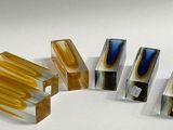 several pieces of glass are arranged in a row on a white surface