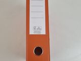 an orange binder with a white label on it sitting on top of a table