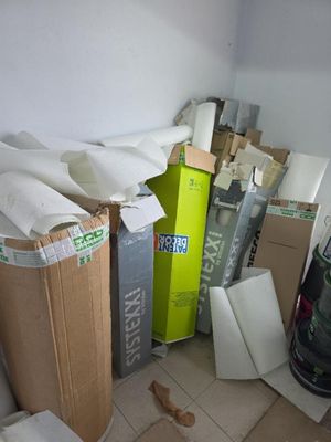a pile of boxes and a vacuum cleaner in a room