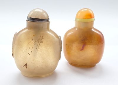 deux vases posés l'un à côté de l'autre sur une surface blanche