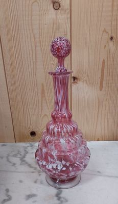 un vase en verre rose posé sur une table en marbre
