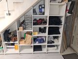 a white shelf with lots of shoes on it