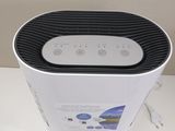 a white and black air purifier sitting on a table