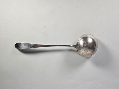 une cuillère posée sur une surface blanche