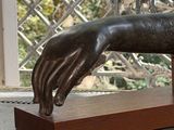 a bronze statue of a dog on a wooden stand