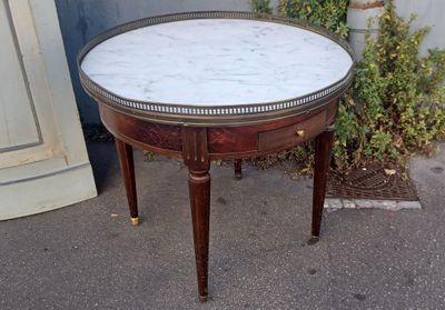 a small table with a marble top on a sidewalk