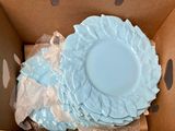 many plates in a box with plastic wrap around them