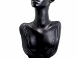 a black mannequin with a gold necklace on it
