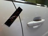 a sticker on the door handle of a white car