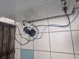 a white tile floor with a blue and black electrical plugged into it