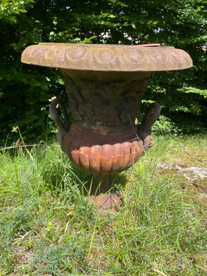 un vase en pierre posé au milieu de l'herbe