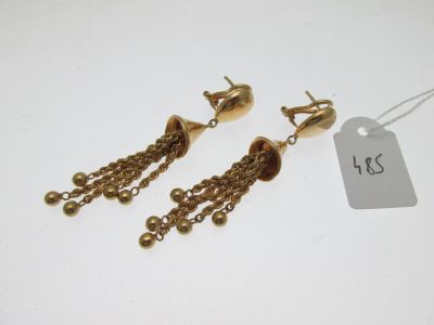 une paire de boucles d'oreilles dorées ornées de chaînes pendantes