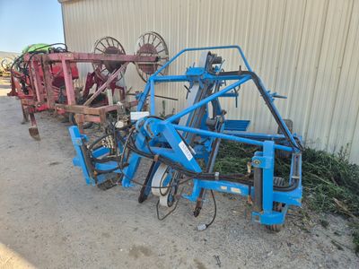 un tracteur bleu équipé d'une charrue à l'arrière