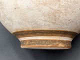 a close up of a white vase with a brown stripe on it