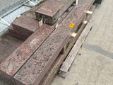 a pile of red granite blocks on the ground