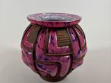 a pink vase with a brown design on it