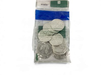 un sac de pièces d'argent posé sur une surface blanche