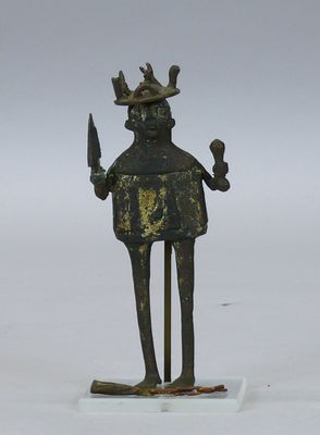 une statue représentant un homme tenant un couteau et portant une couronne sur la tête