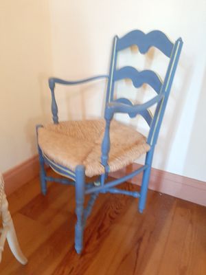 un chien debout à côté d'une chaise bleue dans une pièce