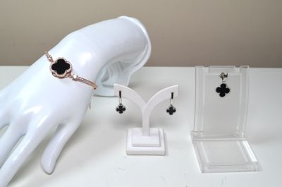 une présentation de bijoux sur une table, à côté d'une main