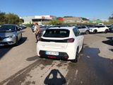 a white car parked in a parking lot next to other cars