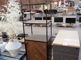 a lot of furniture in a warehouse with a plant in the middle of the room