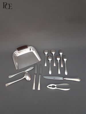 un service d'argenterie posé sur une table, comprenant un couteau, une fourchette, une cuillère et un repose-couteau